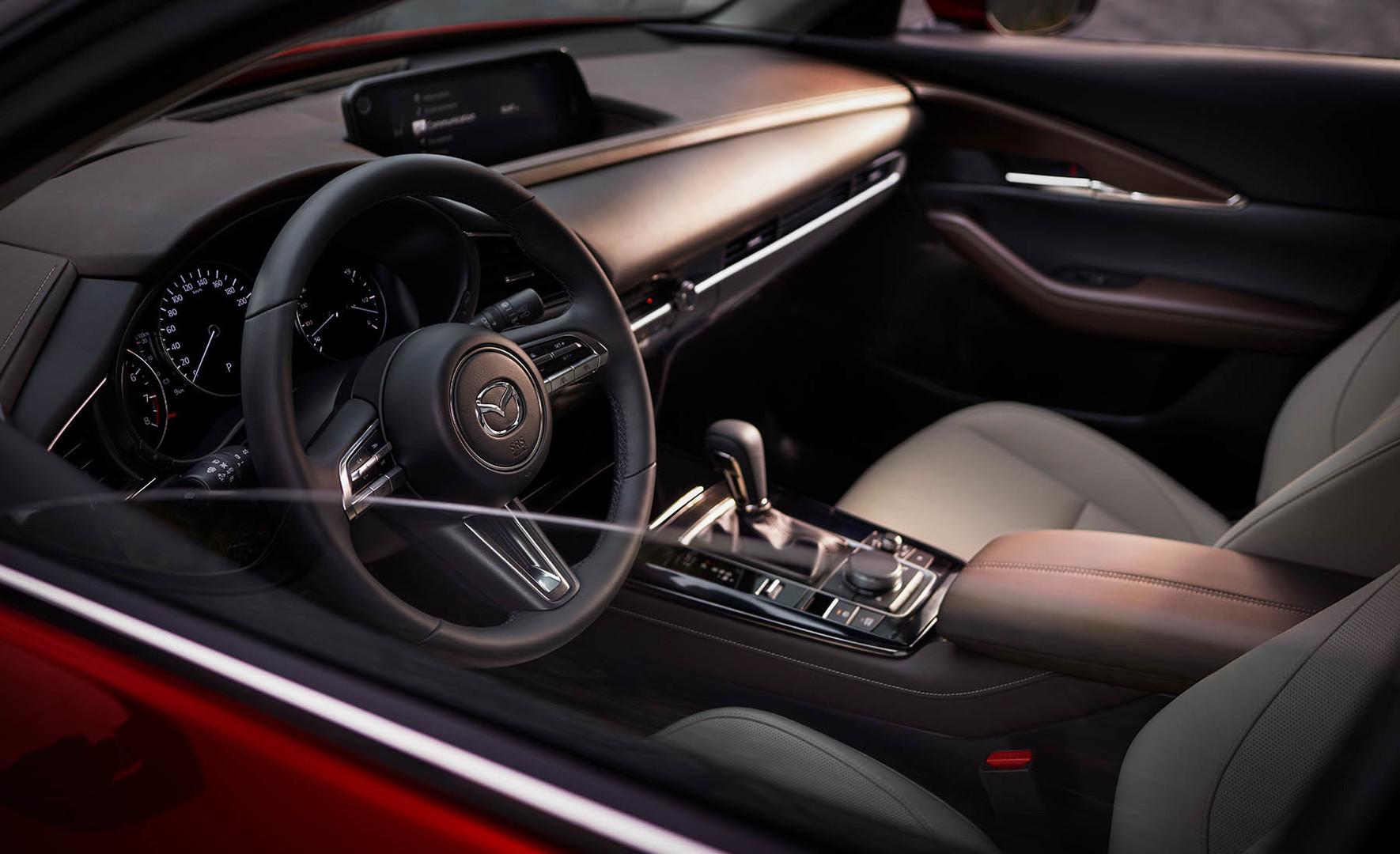 L’abitacolo di Mazda CX-30 Homura è intimo e raffinato, grazie a lussuosi dettagli artigianali come i sedili in tessuto nero e le eleganti cuciture rosse su tutta la lunghezza.